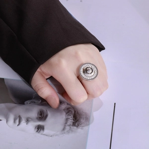 Close-up of a silver stainless steel ring with white zircons on a fashion magazine