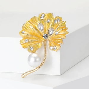 Detail of yellow ginkgo leaf brooch with gold glitter, rhinestones, and white pearl