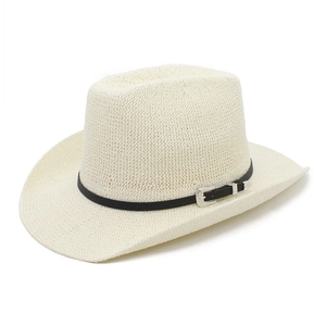 Détail d'un chapeau de paille ivoire avec bandeau en cuir noir et boucle argentée ciselée