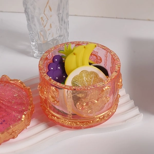 Detail of carousel resin storage jar with gold glitter and miniature fruit decorations
