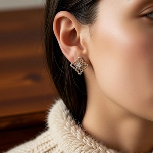 Detail of rose gold geometric stud earring featuring hollow design and micro-set zircon