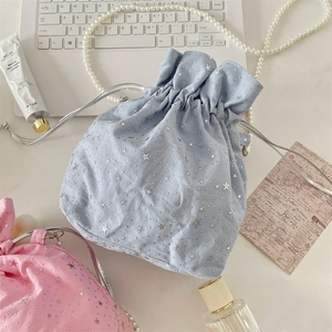Close-up of star pattern canvas bag with pearl chain strap and drawstring closure