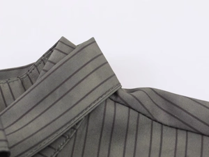 Detailed view of dark olive green shirt collar featuring classic black stripes and fine stitching