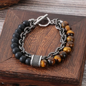 Detail of layered beaded bracelet with tiger eye stone and black matte beads on wood