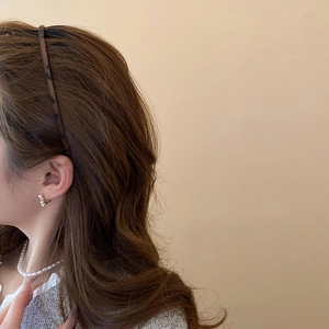 Close-up of leopard print headband and elegant pearl earrings set for women