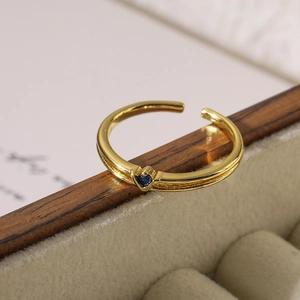 Macro detail of 18K gold-plated ring featuring a deep blue heart-shaped cubic zirconia