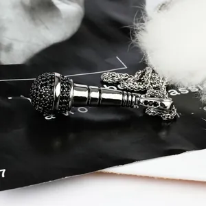 Macro shot of hip-hop microphone pendant with black diamonds and thick curb chain