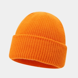 Close-up of orange knit beanie showing detailed ribbed texture and soft warm winter fabric