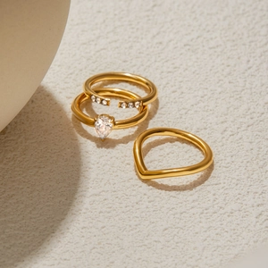 Detail view of a 3-piece gold plated ring set featuring a teardrop zirconia and V-band