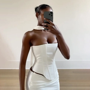 Dettaglio del set corsetto in raso bianco e gonna coordinata su una modella