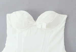 Détail de la robe bustier blanche avec décolleté en cœur, nœud et structure à baleines