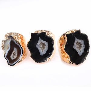 Anelli di geode d'agata naturale con bordi placcati in oro e fasce regolabili su sfondo bianco