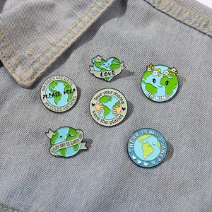 Set of six colorful enamel earth-saving pins on denim jacket for eco-awareness