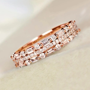 Detailed side view of a triple-row rose gold ring with alternating zircon stone settings