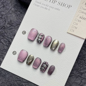 Detail of purple cat eye press-on nails with silver 3D rabbit charms on display