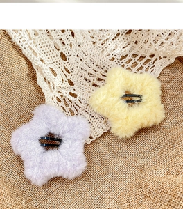 Detail of plush star hair clips in cream and purple colors with metal BB clip base