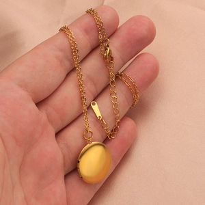 Detailed view of a round 316L stainless steel locket necklace in polished gold finish
