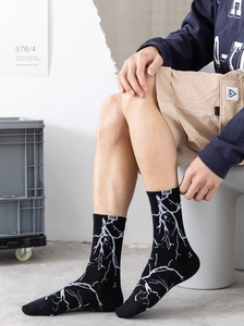 Détail des chaussettes en coton avec motifs d'éclairs blancs et étiquette tissée ZHI