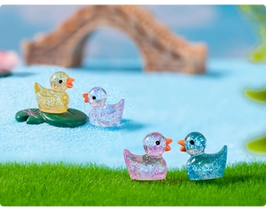 Detail of colorful glitter resin mini duck figurines in a miniature garden landscape
