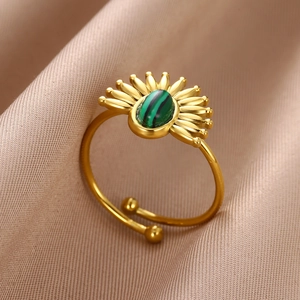 Vue macro détaillée d'une bague rétro dorée avec une pierre verte ovale sertie