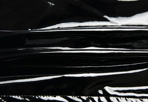 Macro shot highlighting the glossy texture and sleek finish of black patent leather