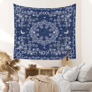 Detailed close-up of Bohemian tapestry with moon and sun patterns in a bedroom setting