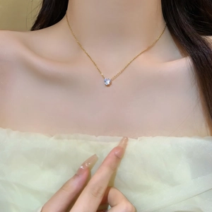 Close-up of 18K gold plated heart zircon necklace worn on woman's neckline