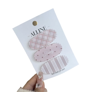 Three-piece set of cute pink hair clips with checkered, heart, and striped wave patterns