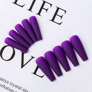 Macro detail of purple matte coffin press-on nails displayed on a white background