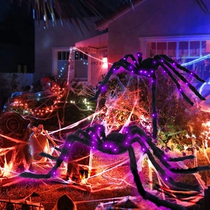 Giant plush Halloween spiders with purple LED lights on a spiderweb in a yard