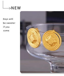 Detailed close-up of textured gold stud earrings with star relief on glass rim