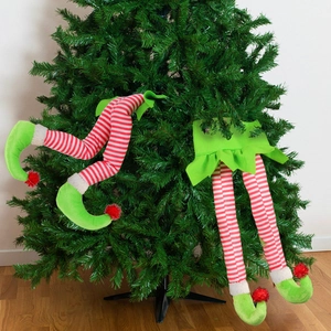 Funny Christmas elf legs sticking out of a tree, festive red and green fabric decoration
