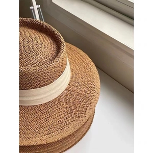 Straw boater sun hat with wide brim and white decorative ribbon for summer beach vacation