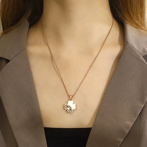 Close-up of a rose gold hollow clover necklace worn on a model's neck for a trendy look