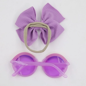 Detail of purple bow headband and round sunglasses accessory set for kids