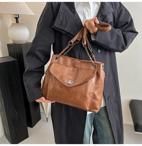 Dettaglio borsa tote in pelle PU marrone con tracolla a catena e chiusura a girello