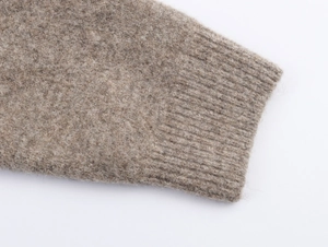 Close-up of oatmeal knit cardigan sleeve with ribbed cuffs and fuzzy wool texture