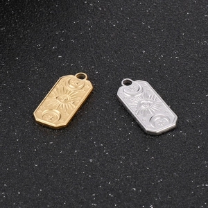 Gold and silver stainless steel pendants with evil eye, moon and stars on black background