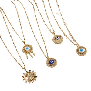 Five gold Evil Eye necklaces with blue enamel and colorful zircon pendants on white background
