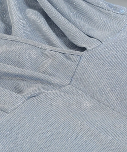 Macro shot of shimmering silver blue metallic knit fabric with elegant ribbed texture