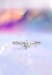 Macro shot of a classic six-prong silver moissanite ring with a reflective mirror base