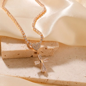 Elegant gold necklace with a crystal cross and diamond-studded heart on silk
