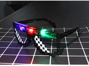 Detail view of glowing LED pixel sunglasses with mosaic frame on a grid surface