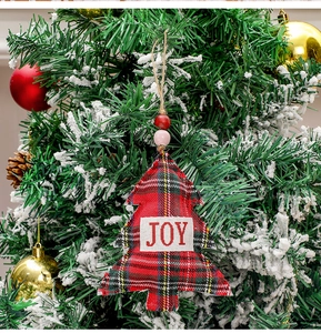 Detail of red and black plaid Christmas tree ornament with JOY text and wooden beads