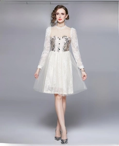Detail of white French vintage dress featuring lace sleeves and tiered mesh skirt