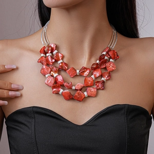 Detail of red tiered bohemian necklace with irregular beads and silver metal layers