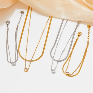Double-layered snake chain bracelet with zircon pendants in gold and silver steel