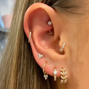 Detailed close-up of golden S925 silver stud earrings set with sparkling zircon stones