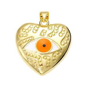 Macro detail of gold heart pendant with evil eye and orange pupil jewelry component