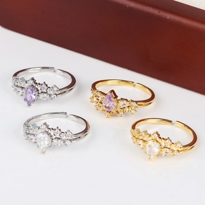 Detailed display of adjustable teardrop zircon rings in gold and silver on a jewelry box